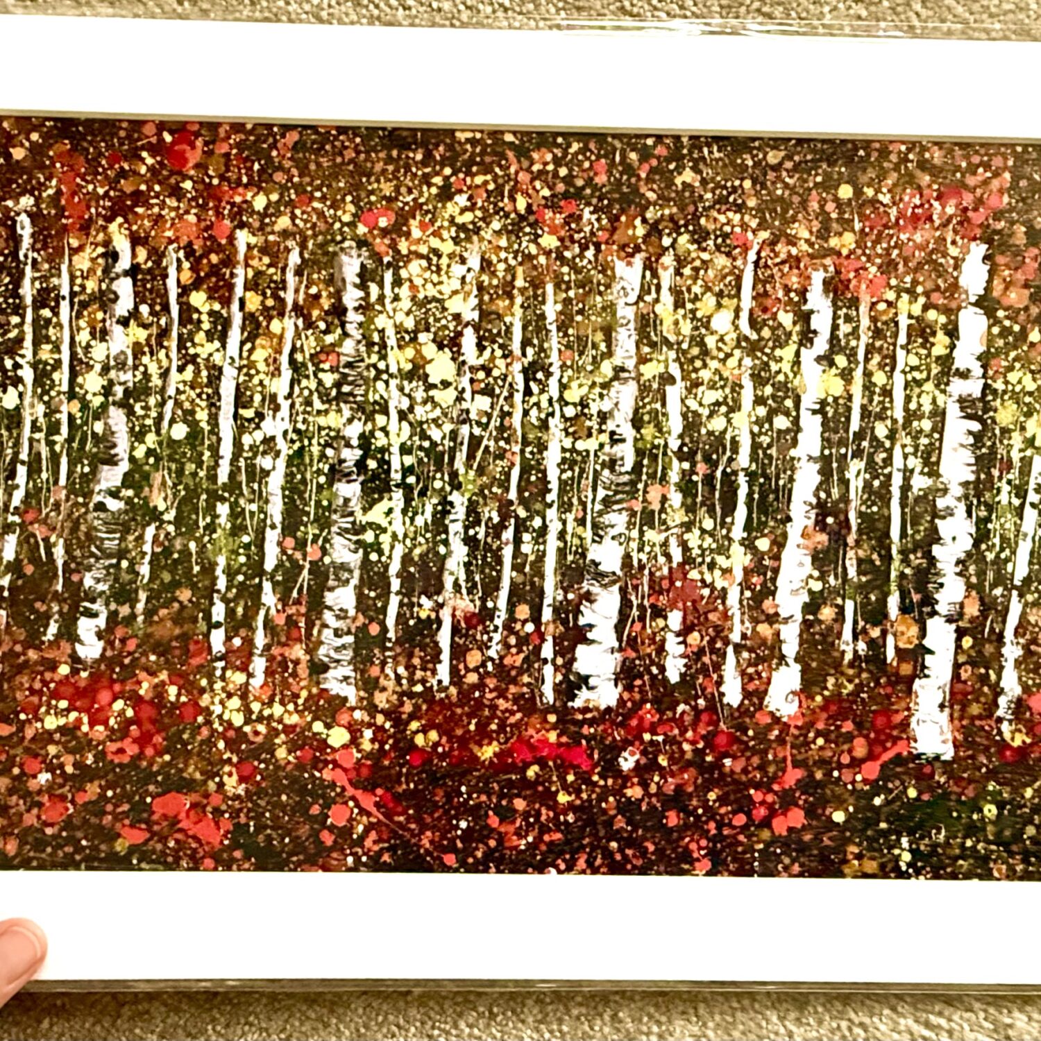 Hand Holding Autumn’s Tranquillity Mounted A3 Print Featuring Colourful Autumn Birch Trees