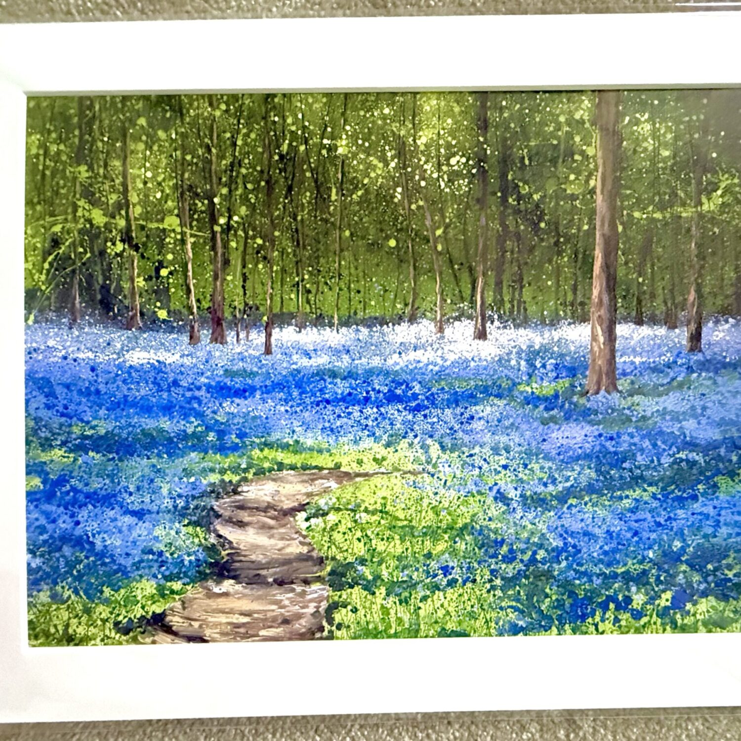 Spring Bluebells A3 Mounted Print By Sally Oasis, Showing A Winding Woodland Path Through Vivid Bluebells Beneath Tall Trees And Fresh Green Foliage.